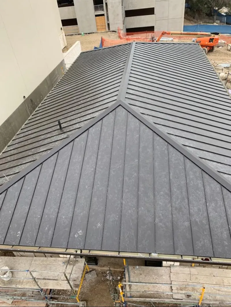 Commercial metal roof construction with crane equipment in Homer